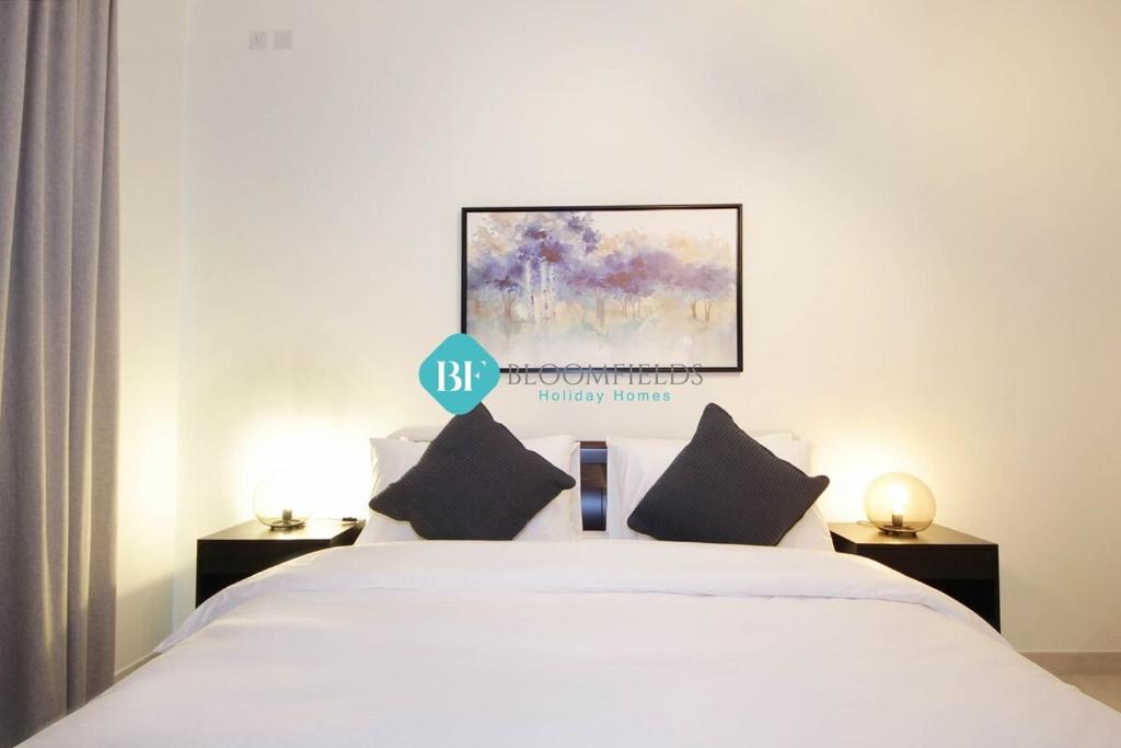 Brand New Luxury 2 Bedroom Apartment في أبوظبي: غرفة نوم بسرير ابيض عليها لافته