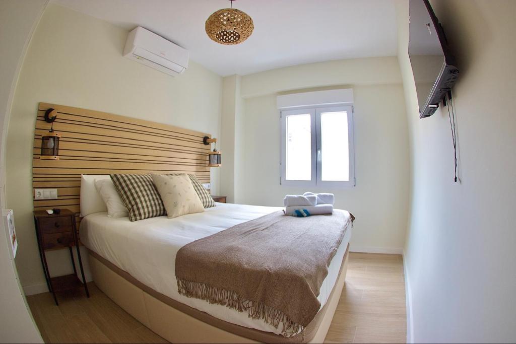 um quarto com uma cama grande e uma cabeceira em madeira em VICTORIA 75 LUXURY em Málaga