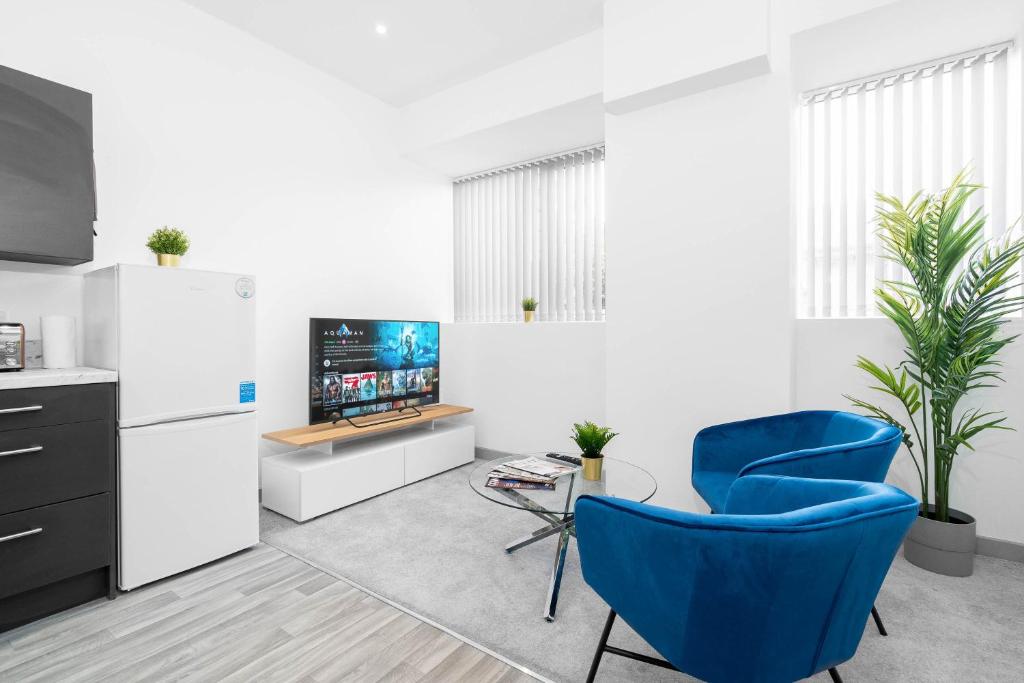 a living room with a blue chair and a tv at Modern Apartment in Brierley Hill - Secure Parking - Wifi & Netflix - 11O in Brierley Hill