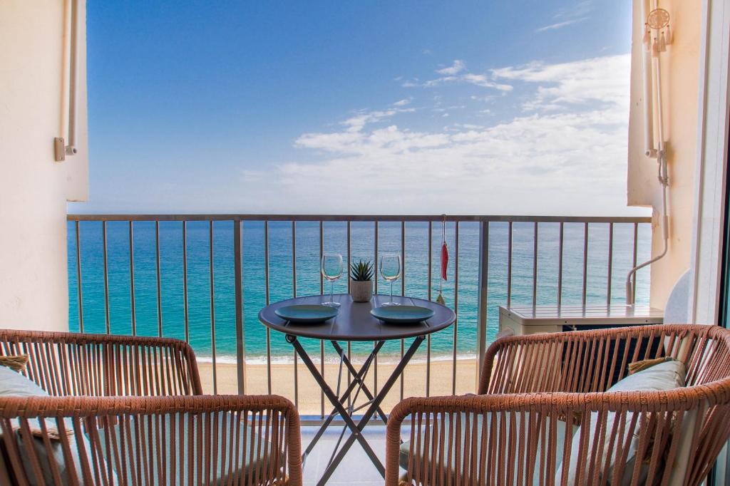 a table on a balcony with a view of the ocean at Bambu Beach Studio by BHomesCostaBrava in Platja d'Aro