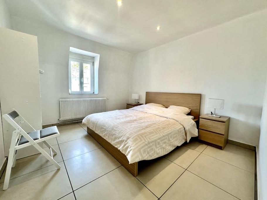 a bedroom with a bed and a chair in it at #Herbie2 - Appartement Mulhouse - Charme &amp; Confort in Mulhouse