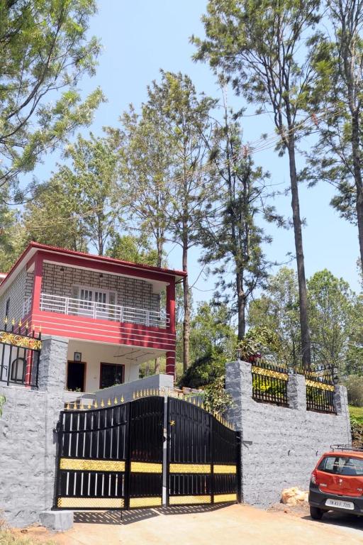 a house with a gate and a car parked in front at Franc Villa - Kothagiri in Kotagiri