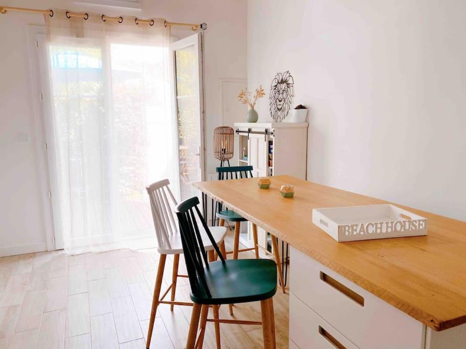 - une cuisine avec une table, des chaises et un comptoir dans l'établissement Maison de vacances proche plage des Sables d'Olonne, à La Pironnière