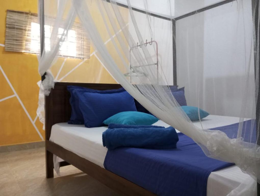 a bedroom with a bed with a mosquito net at freedom house in Unawatuna