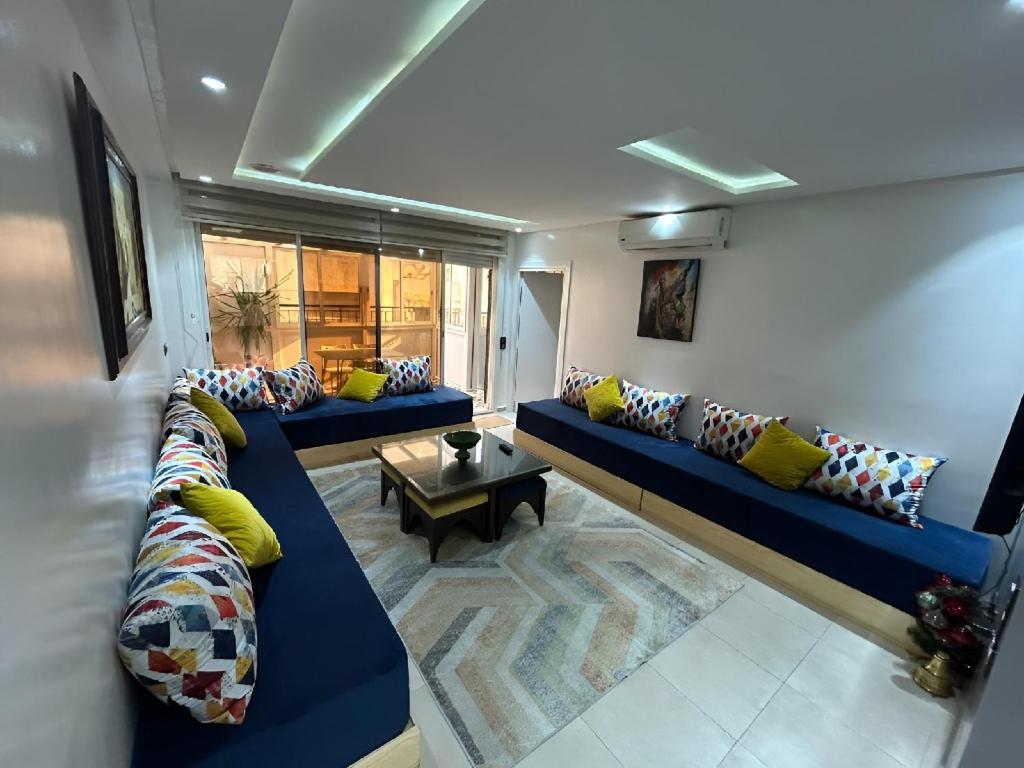 a living room with two blue couches and a table at Luxueux appartement au centre de Rabat in Rabat