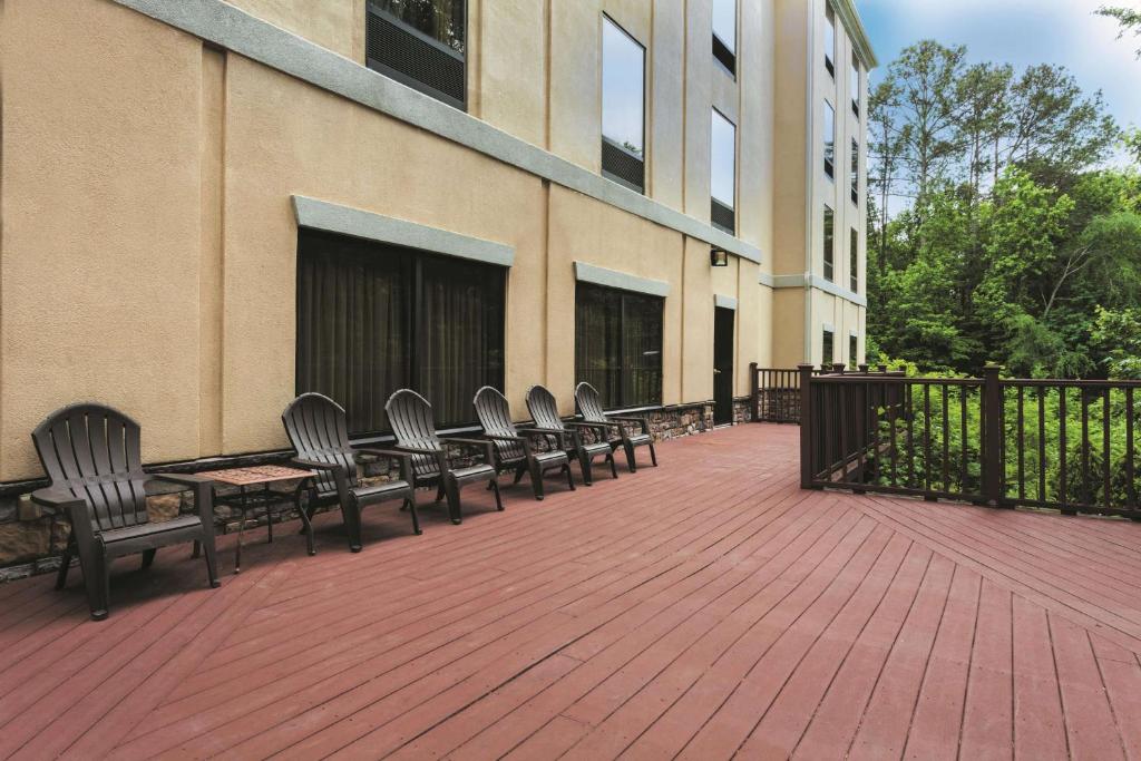 eine Terrasse mit Stühlen und Tischen sowie ein Gebäude in der Unterkunft La Quinta by Wyndham Covington in Covington