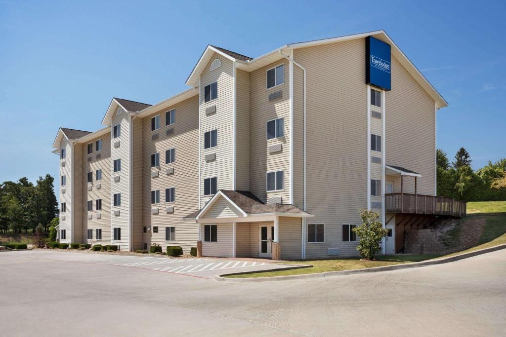 a large apartment building with a parking lot at Travelodge by Wyndham McAlester in McAlester