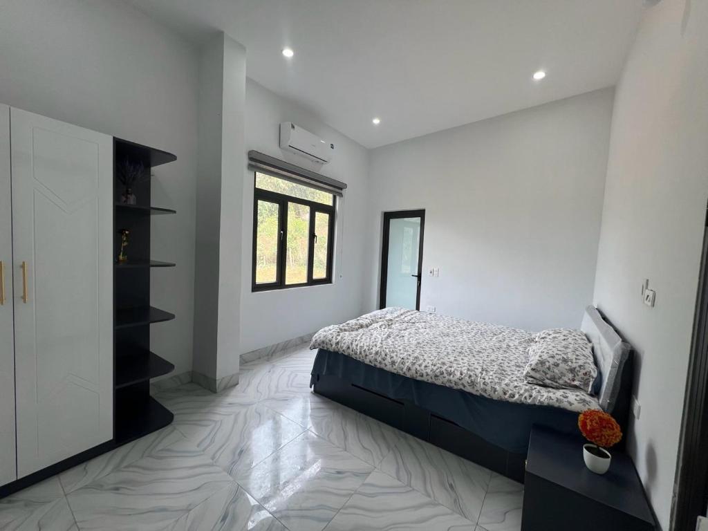 a white bedroom with a bed and a window at Homestay 68 Hoà Bình in Hanoi