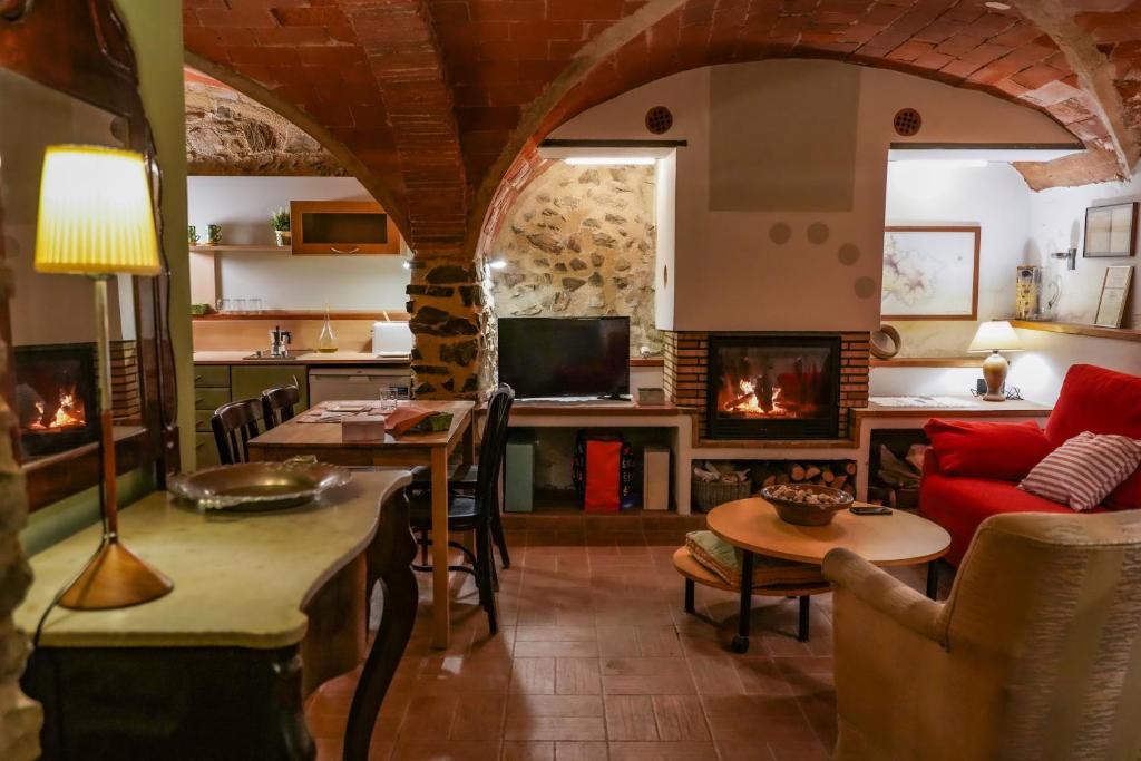 Vilamaniscle的住宿－Ca La Serena - Sant Josep，客厅设有红色的沙发和壁炉