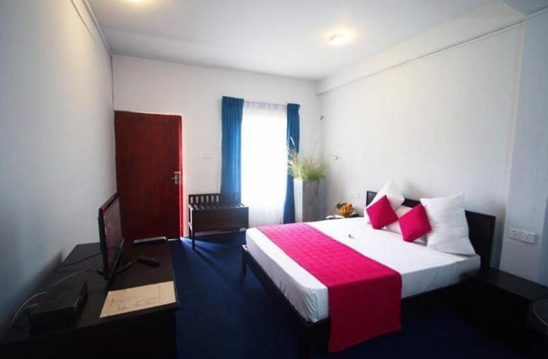 1 dormitorio con 1 cama grande con manta roja en Kothmale Holiday Resort en Gampola