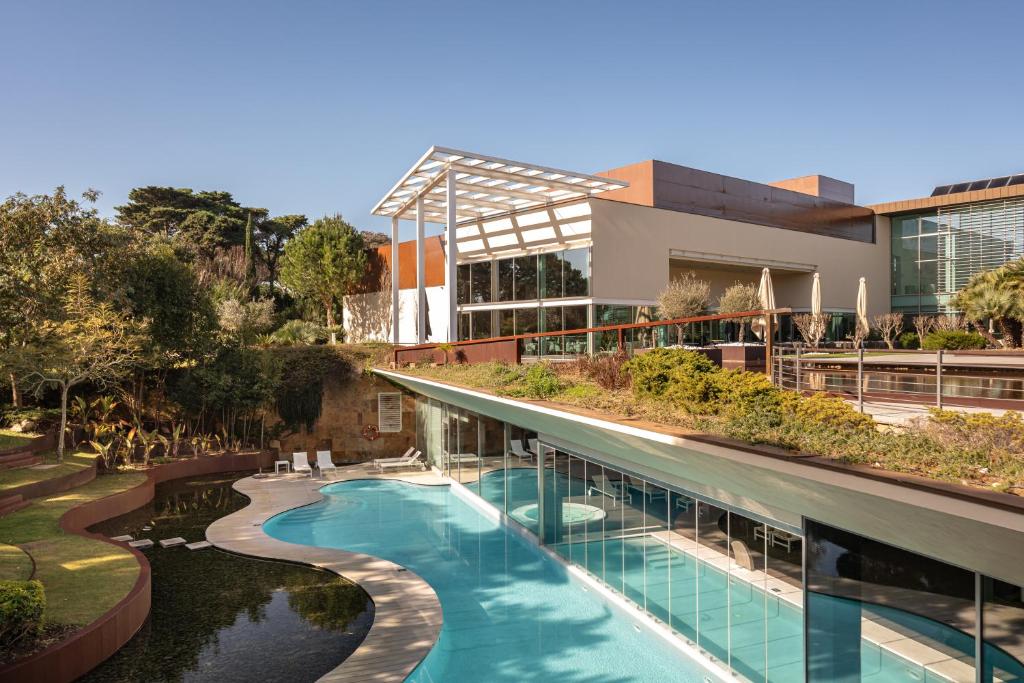 - une vue extérieure sur un bâtiment avec une piscine dans l'établissement Onyria Marinha Boutique Hotel, à Cascais