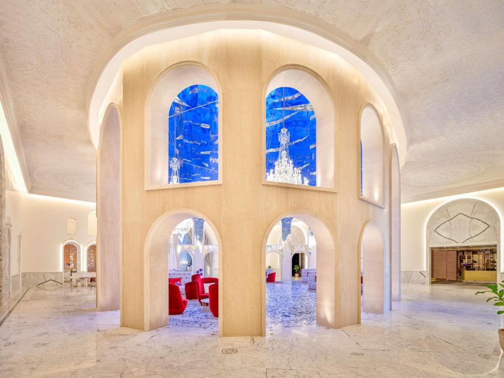 una grande camera con archi e finestre in un edificio di Raffles Doha a Doha