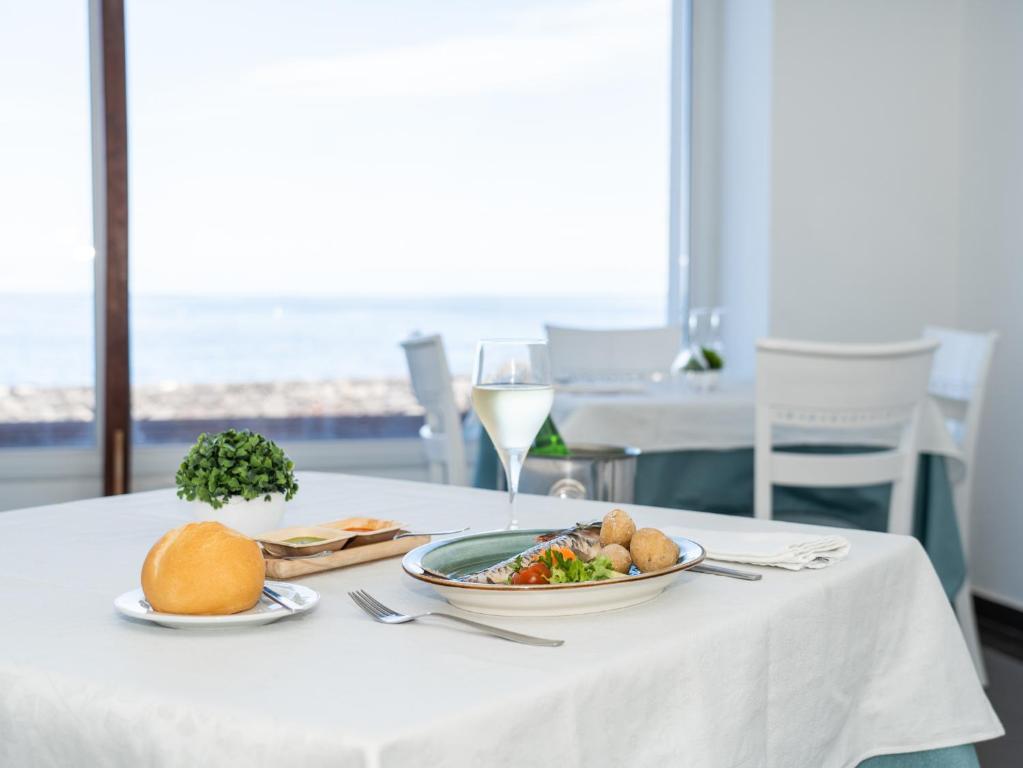 a table with a plate of food and a glass of wine at Balneario Pozo de la Salud in Sabinosa