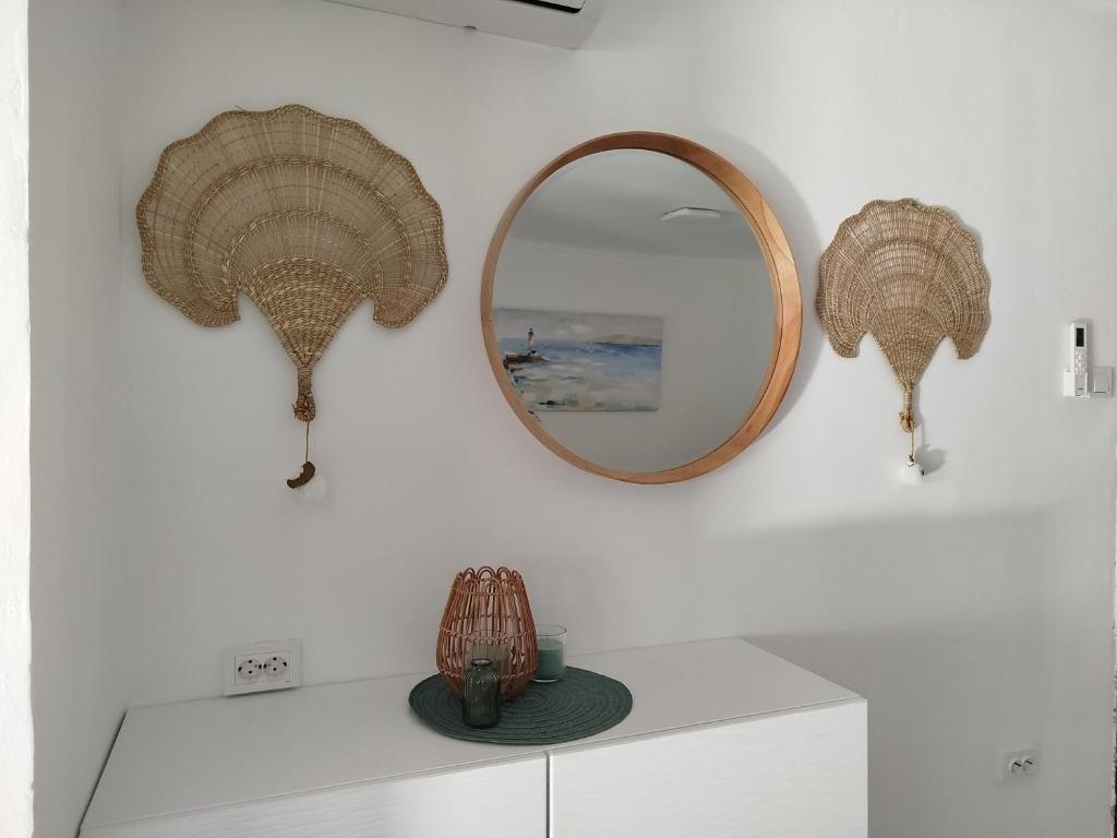 uno specchio su un muro con un vaso su un bancone di Apartman Iva a Novalja (Novaglia)