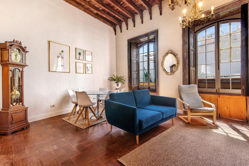 a living room with a blue chair and a table at Apto Pepita - Casa San Marcial in Triana