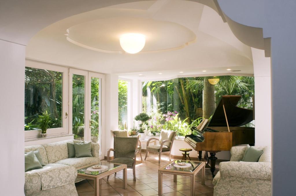 a living room with a piano and a couch at Hotel Villa Angelica in Ischia