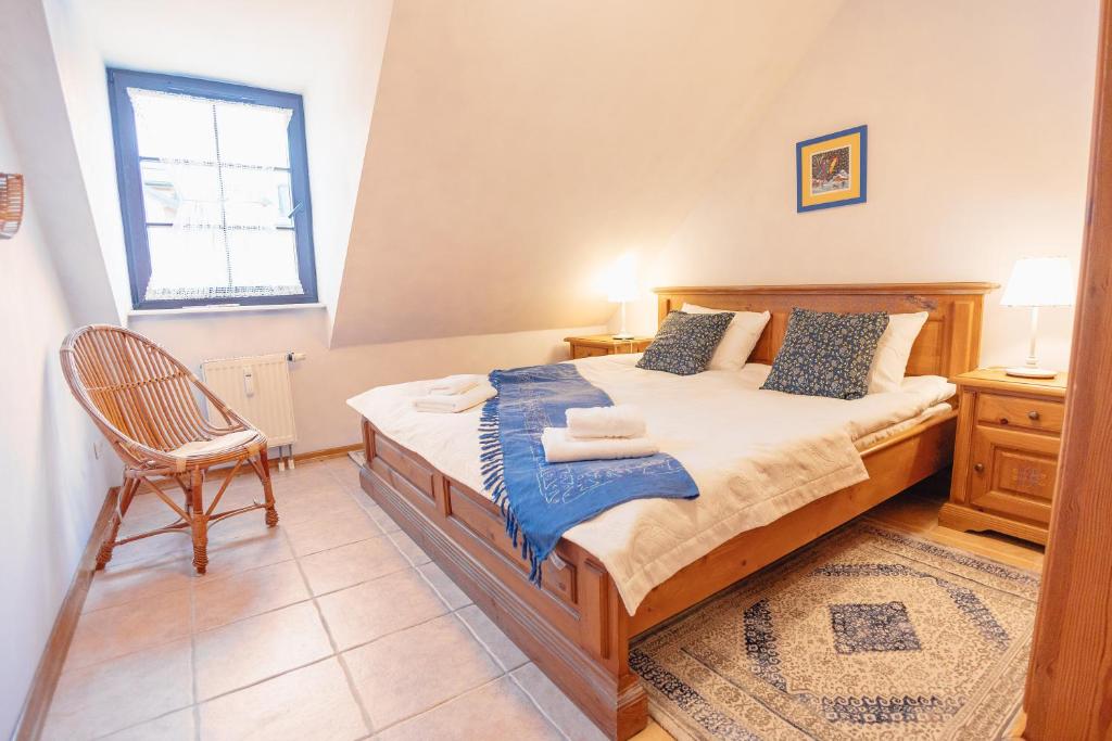 a bedroom with a bed with a chair and a window at Apartamenty Kazimierz Dolny in Kazimierz Dolny