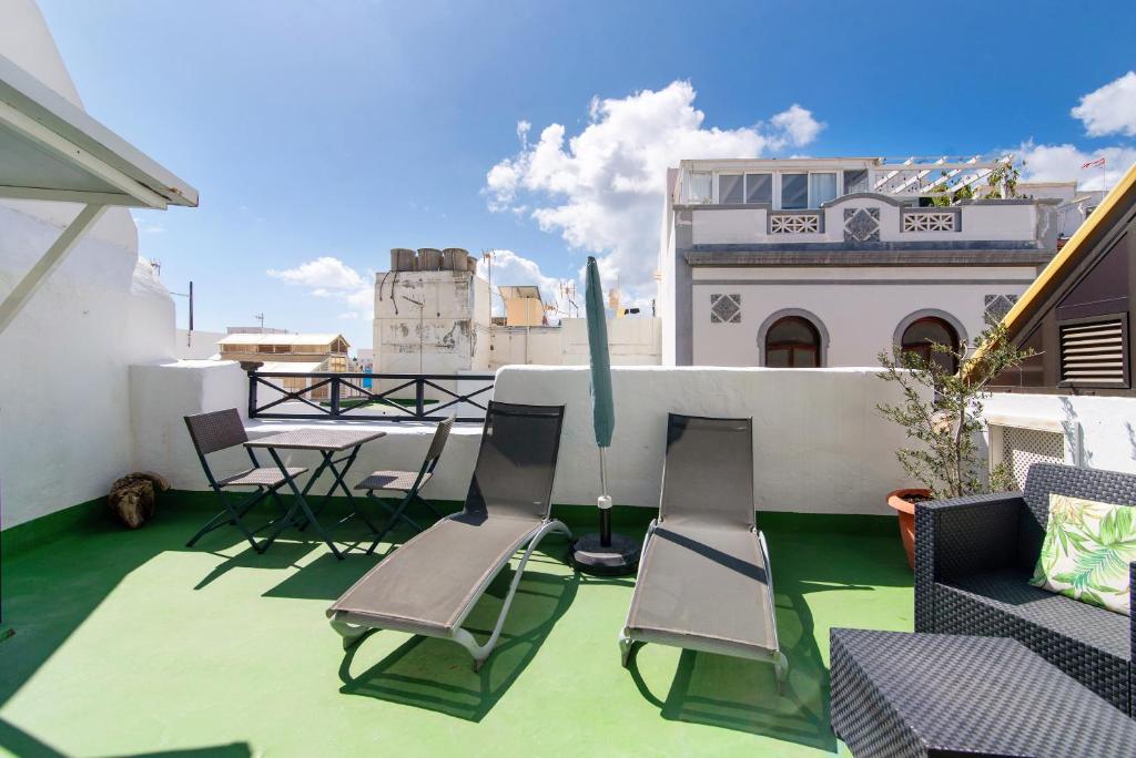 a patio with chairs and a table on a roof at Apto Azahara - Casa San Marcial in Las Palmas de Gran Canaria