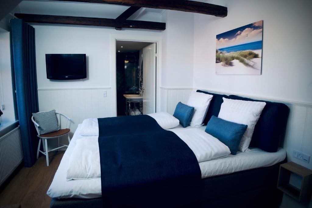 a bedroom with a large bed and a couch at Plesners Badehotel in Skagen