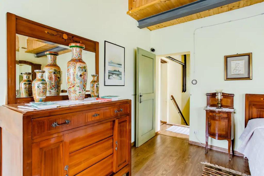 a bedroom with a dresser with vases on it at Agriturismo Campo Aperto in Belvedere Ostrense