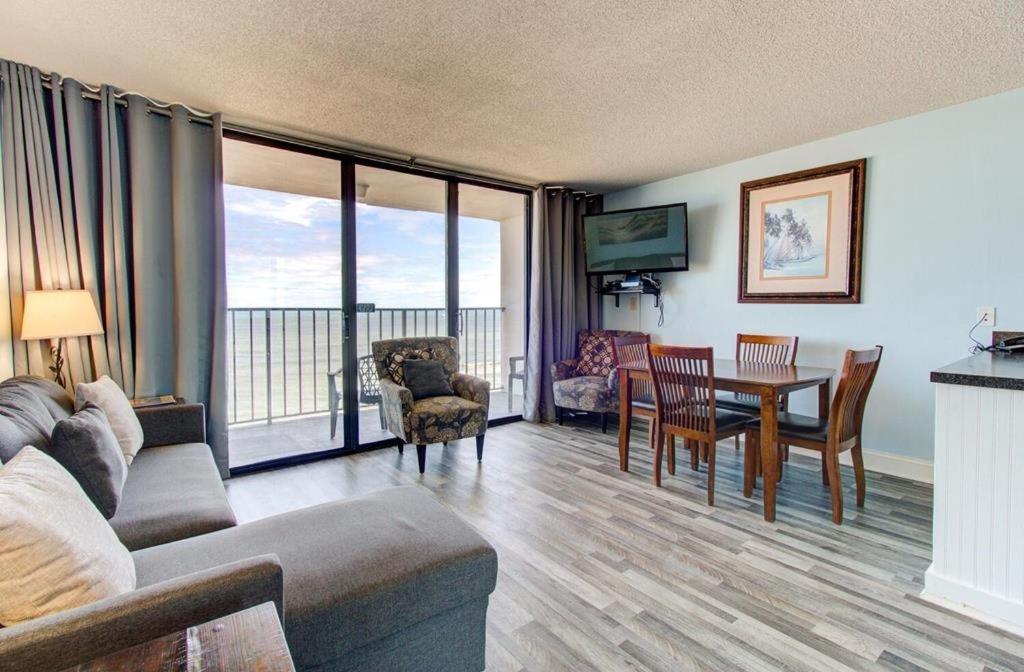 een woonkamer met een bank en een tafel en stoelen bij 0809 Carolina Shores by Atlantic Towers in Carolina Beach