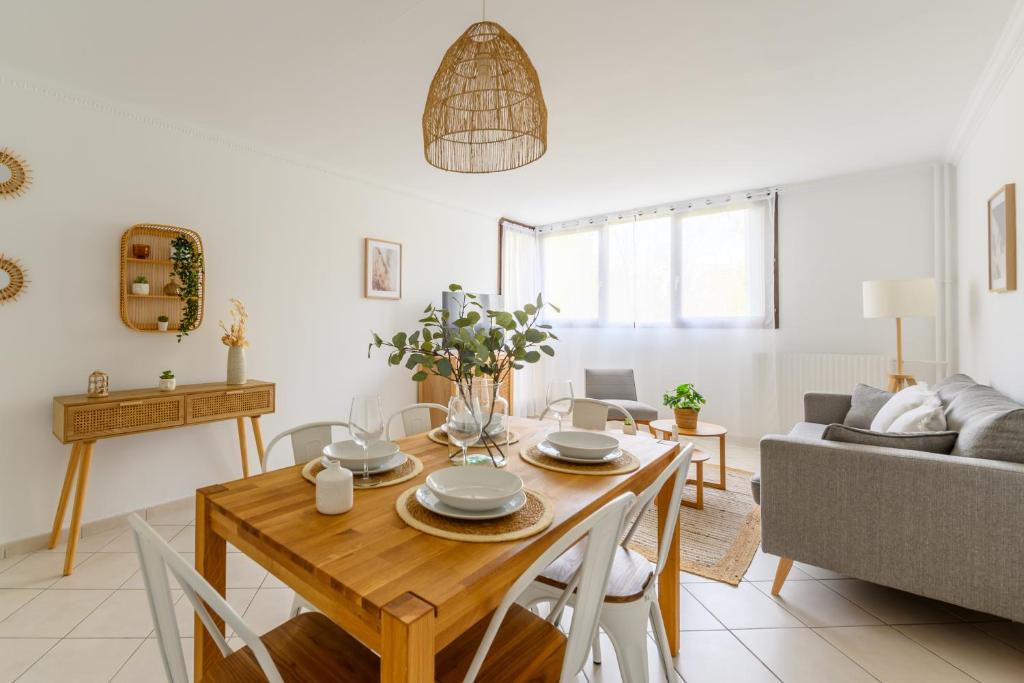 sala de estar con mesa y sofá en Cœur de ville - Au pied du métro - 3 chambres, en Bobigny