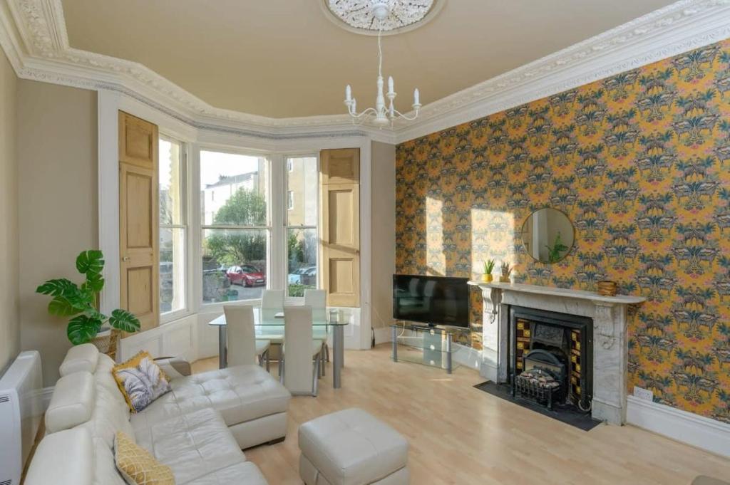 een woonkamer met een witte bank en een open haard bij Gorgeous Apartment Seconds from Seafront Clevedon in Clevedon