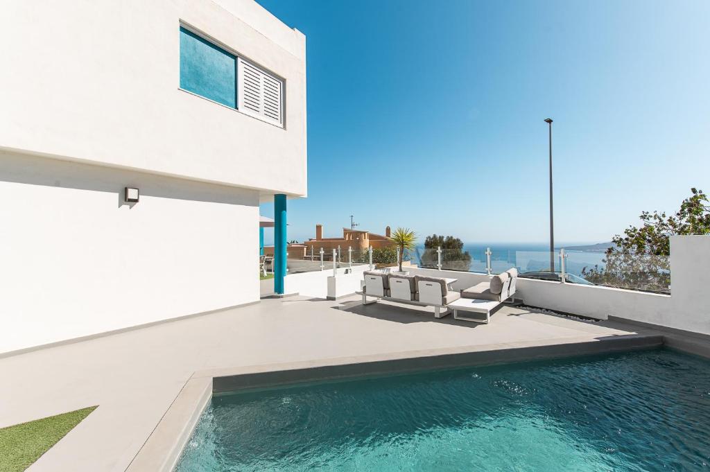 une maison avec une piscine à côté d'un bâtiment dans l'établissement Chalet con piscina en Tabaiba by Alterhome, à Santa Cruz de Tenerife