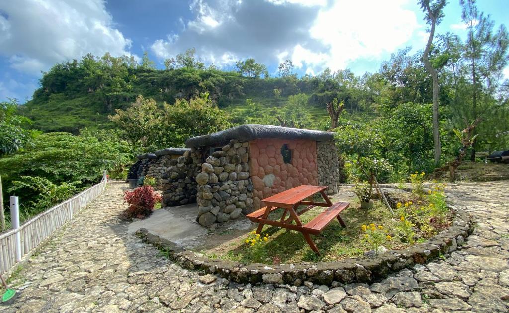 a small building with a picnic table in a garden at PALEO Stone Age in Karangwetan