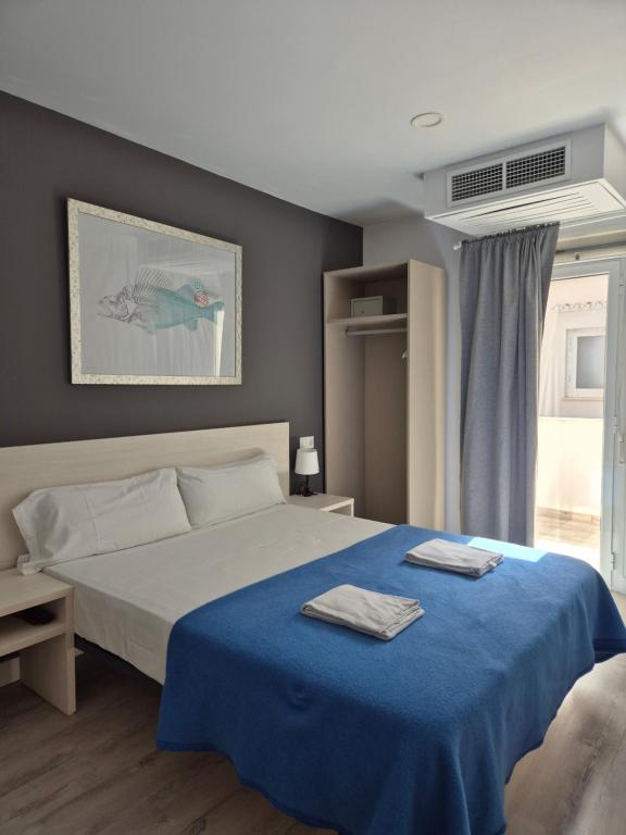 a bedroom with a bed with two towels on it at Blu Hostal Diana in Port d'Alcudia