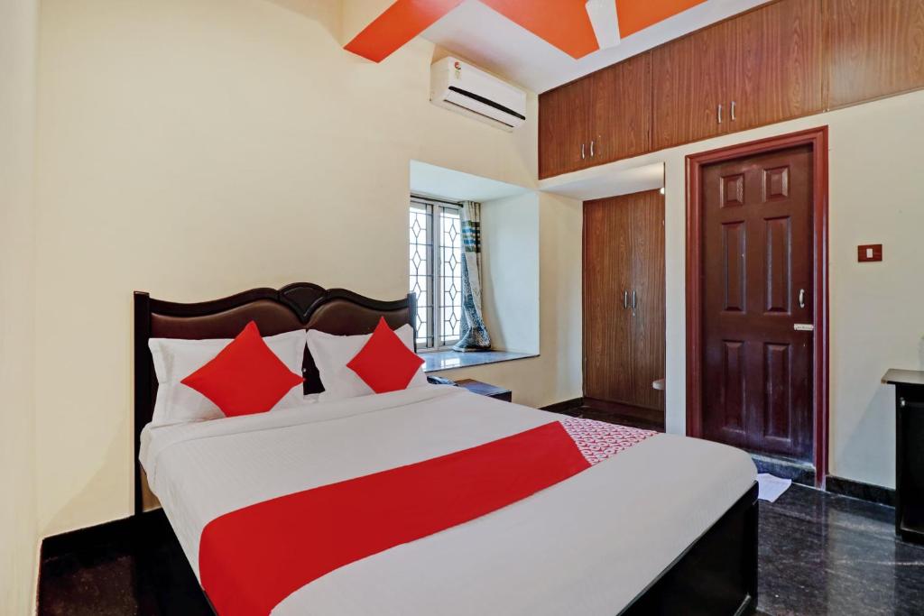 una camera da letto con un grande letto con cuscini rossi di OYO Blooms Inn a Bangalore