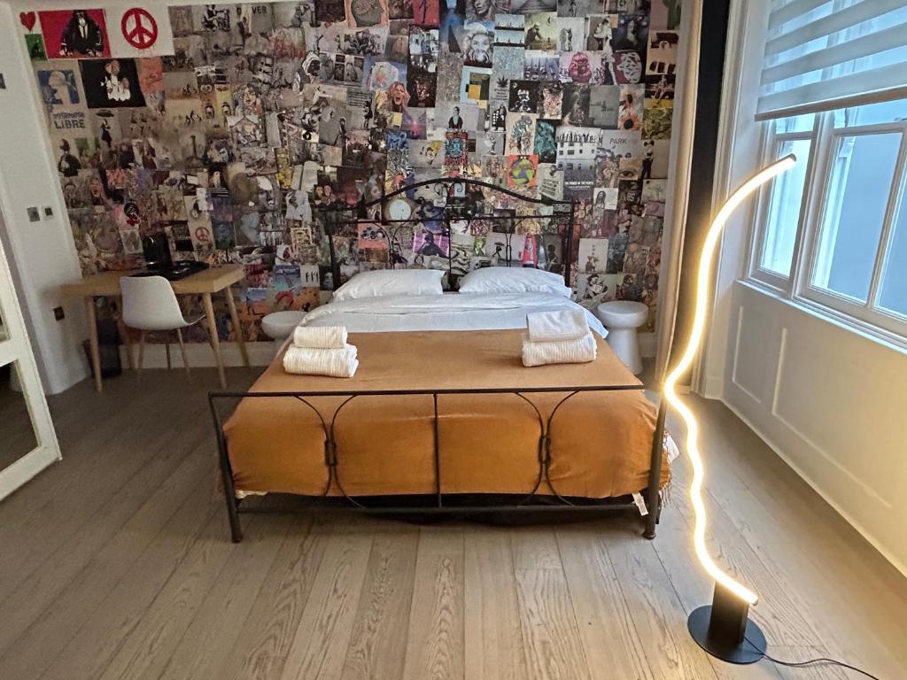 ein Schlafzimmer mit einem Bett und einer mit Fotos bedeckten Wand in der Unterkunft Pop Art Luxury Room Marylebone in London