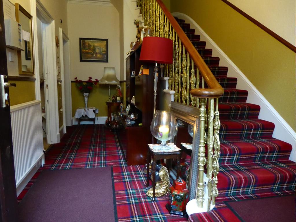 a hallway with a spiral staircase with a red carpet at Seashells Guest House in Aberdeen