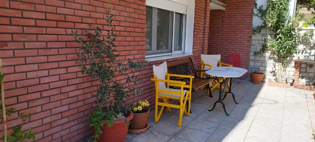 a patio with a table and chairs next to a brick wall at Virginia Apartment in Thessaloniki