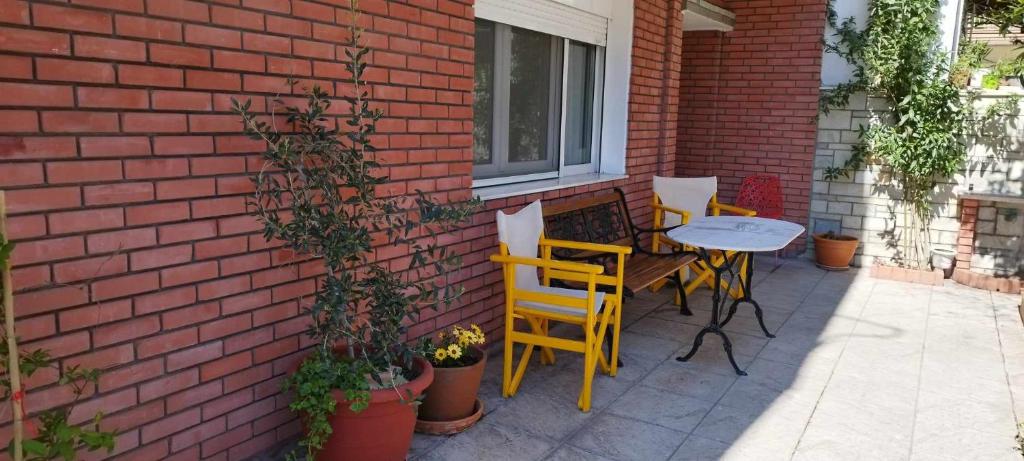 d'une terrasse avec une table et des chaises à côté d'un mur en briques. dans l'établissement Virginia Apartment, à Thessalonique