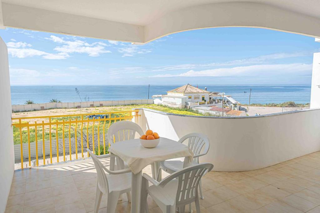 una mesa y sillas en un balcón con vistas al océano en Apartment Sea view 1B, en Portimão