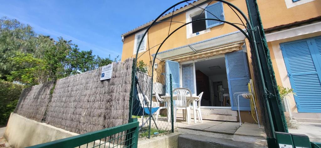une clôture devant une maison avec un portail dans l'établissement Mazet climatisé RDJ plages parking wifi gratuit, à La Londe-les-Maures