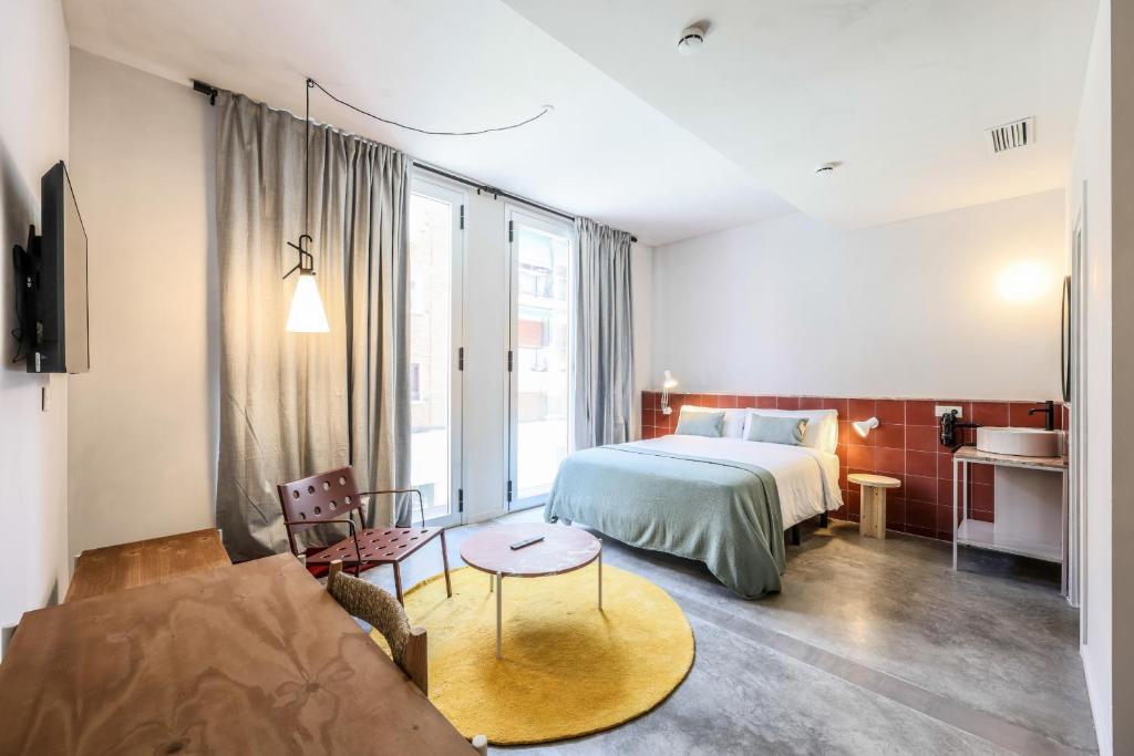 um quarto de hotel com uma cama e um sofá em Madrid Live Coworking - SELF SERVICE - em Madri