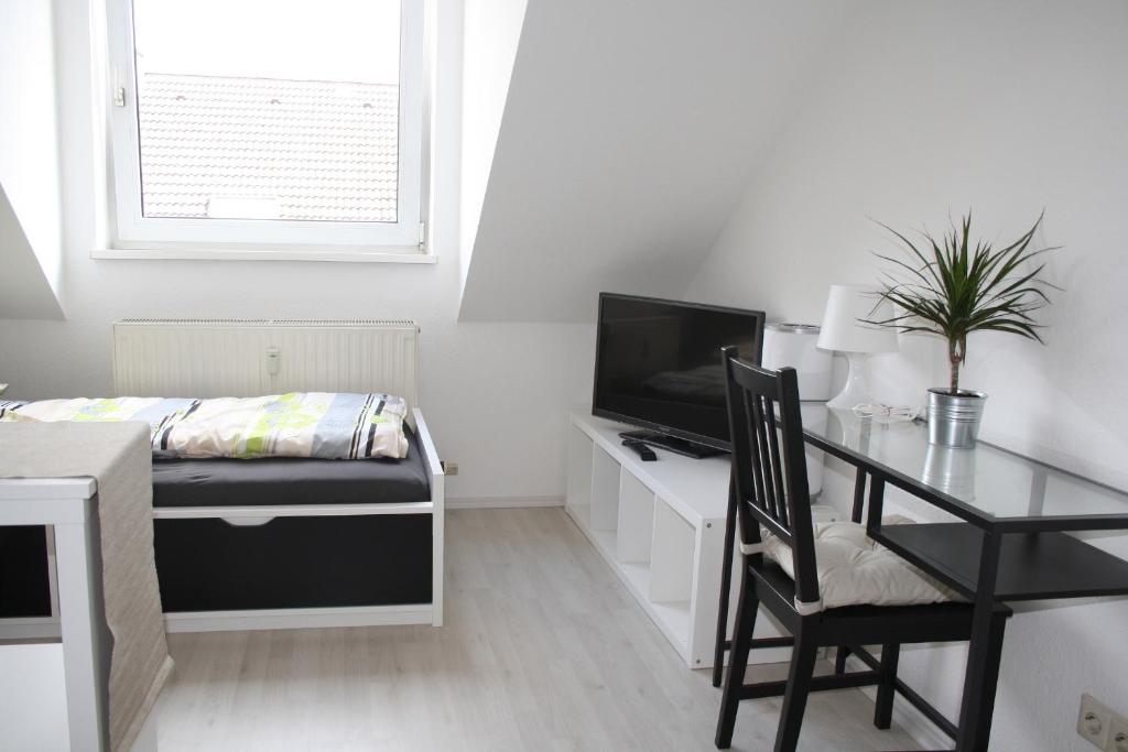 um quarto com uma secretária, uma cama, uma mesa e uma cadeira. em Schönes kleines Apartment direkt in Mannheim Innenstadt em Mannheim