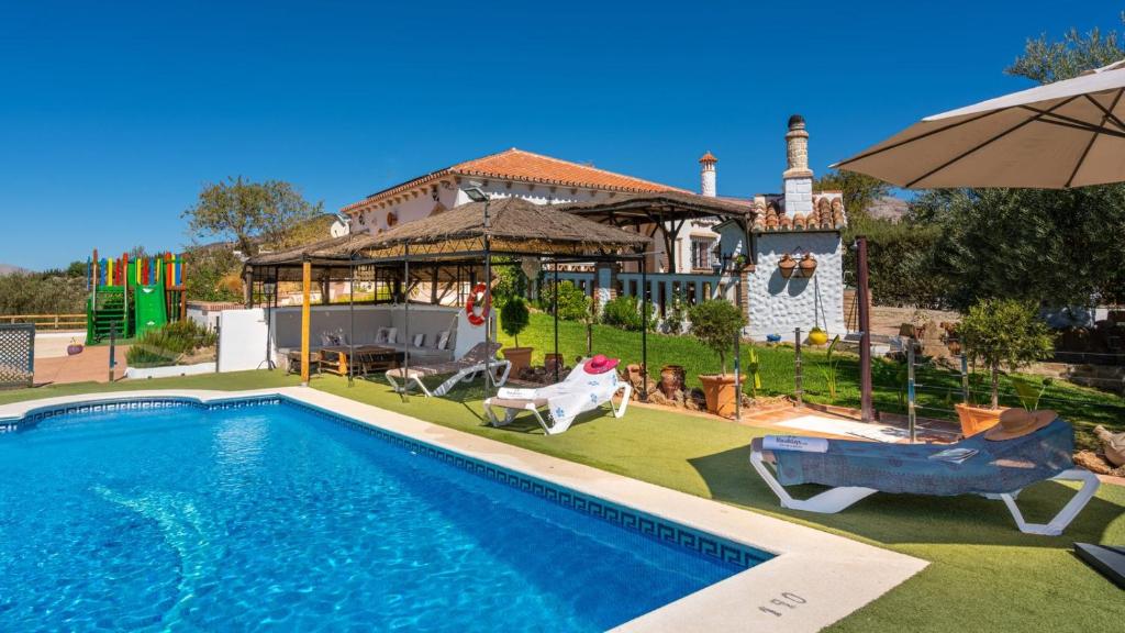 a swimming pool in front of a house at Casa Rural Cayara by Ruralidays in Villanueva de la Concepción
