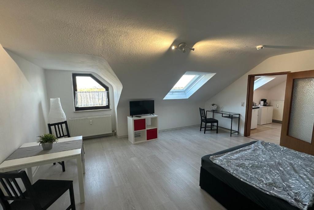 una camera con letto, scrivania e TV di Schönes Apartment im Dachgeschoss in Mannheim Nahe Rheinauer See a Mannheim