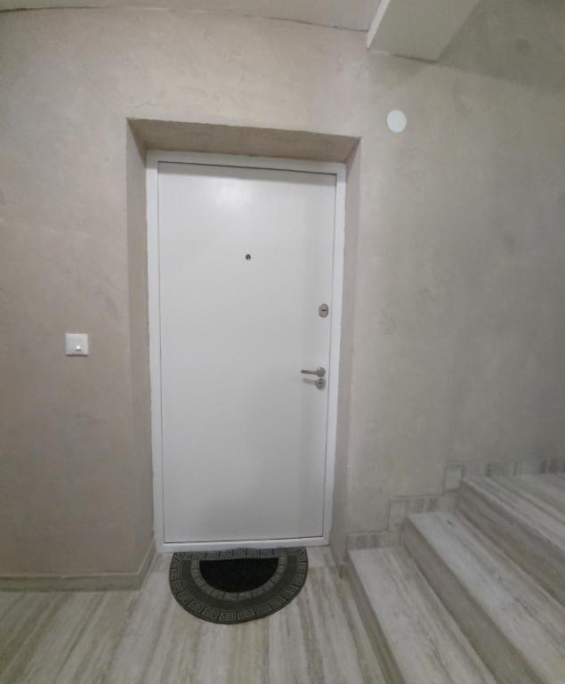 een grote witte deur in een kamer met een trap bij Apartman Elit in Kragujevac