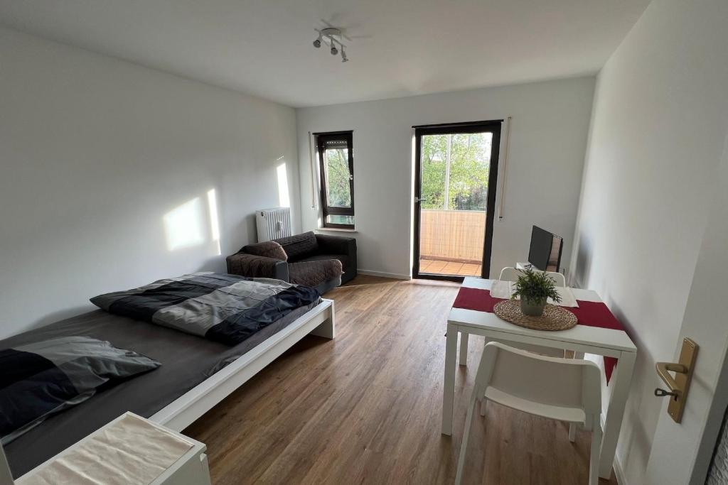 Cet appartement comprend une chambre avec un lit et un salon avec une table. dans l'établissement Schönes Apartment mit Balkon in Mannheim Nahe Rheinauer See, à Mannheim
