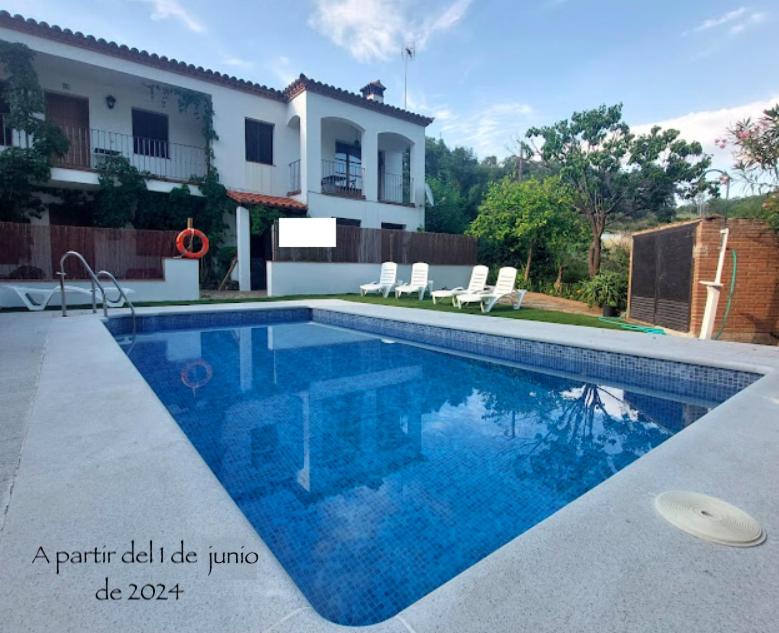 a swimming pool with a frisbee in front of a house at Apartamento Rural Las Palmeras in Almonaster la Real