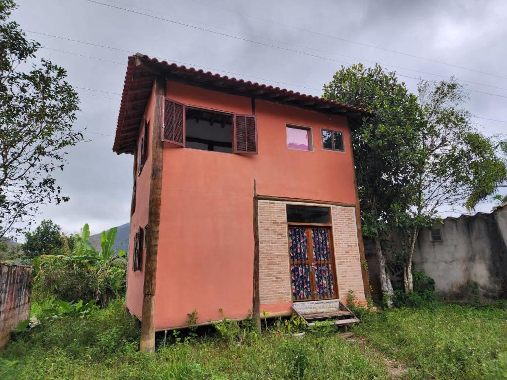 a small orange house with a door in a field at Casa da JUJU - Praia da Lagoinha - Ubatuba in Ubatuba