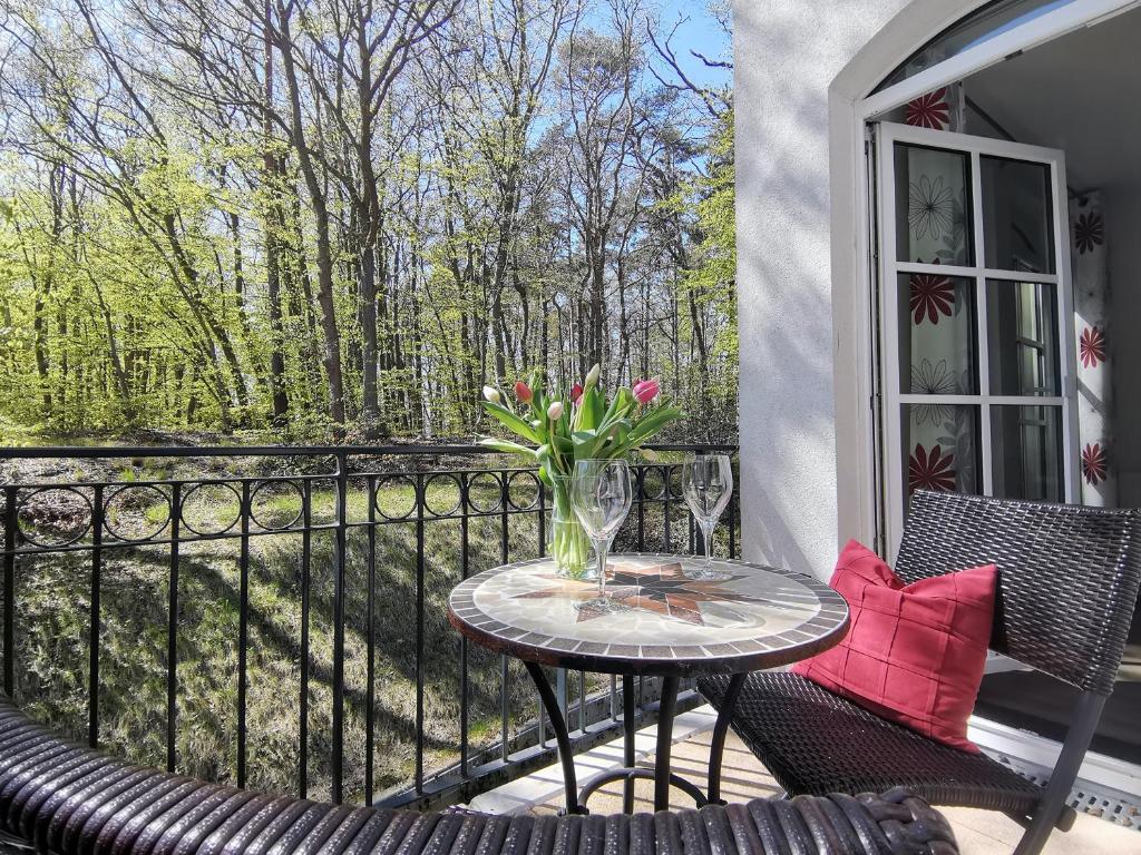 una mesa de patio con un jarrón de flores en el balcón en Haus Meeresblick - Ferienwohnung Sandrose A 2.26 (Ref. 132363), en Baabe