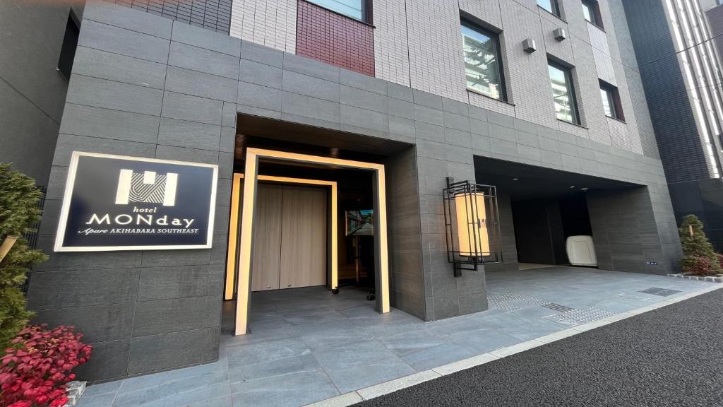 une entrée à un bâtiment avec un panneau sur celui-ci dans l'établissement MONday Apart Asakusabashi Akihabara, à Tokyo