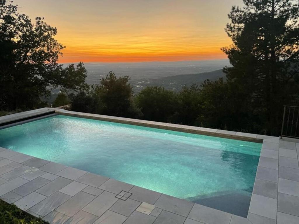 a swimming pool with a sunset in the background at Villa Luana in Cortona