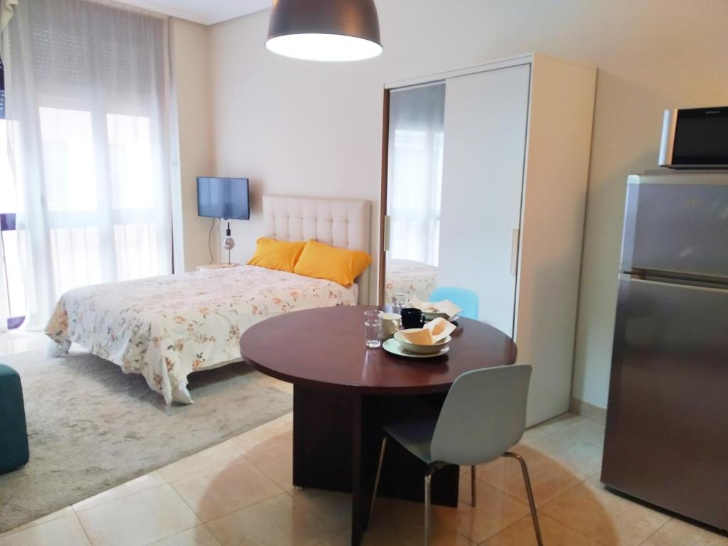 um quarto com uma mesa e uma cama e uma mesa e cadeira em LUNA VERDE apartamento centro con parking em Oviedo