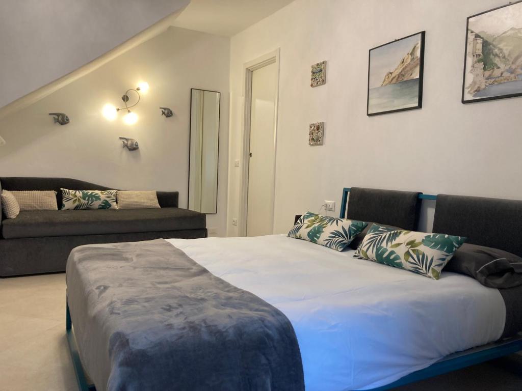 a bedroom with a bed and a couch at Pae veciu camera privata con bagno in Monterosso al Mare